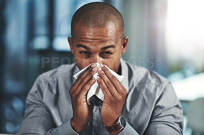 Buy stock photo Portrait of a young businessman blowing his nose in an office