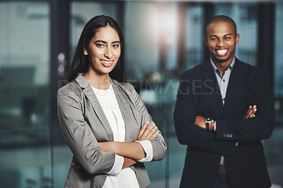 Buy stock photo Portrait of a young businesswoman standing in an office with her colleague in  the background