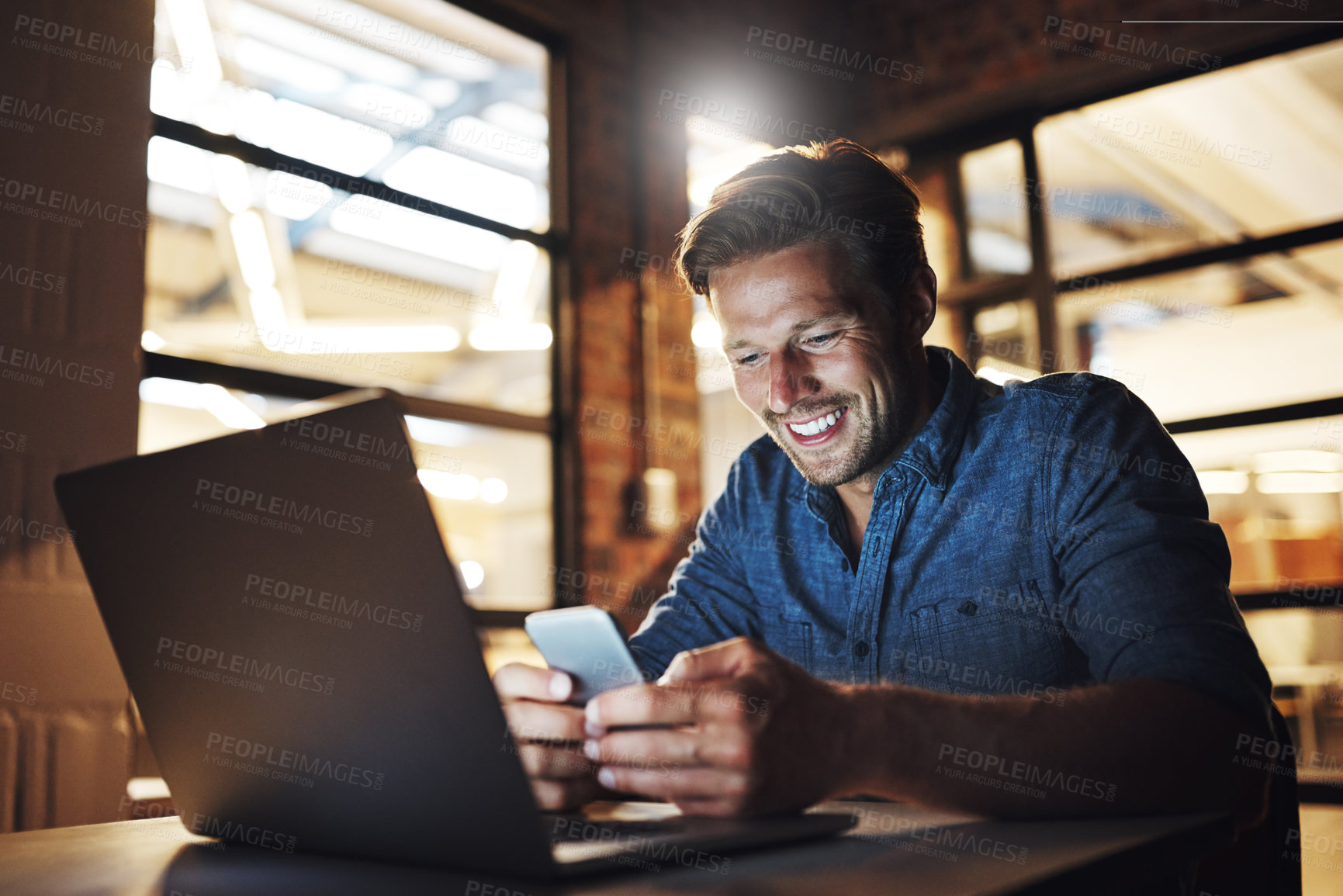 Buy stock photo Business man, laptop and phone with texting for communication, networking and working overtime in office. Male employee, computer and mobile chat at night for project feedback, internet and news app