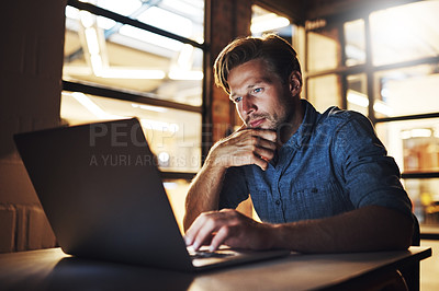 Buy stock photo Cropped shot of a handsome young male designer looking thoughtful while working late in his office
