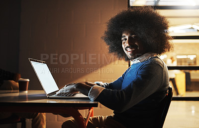 Buy stock photo Cropped portrait of a handsome young male designer using his laptop while working late in the office
