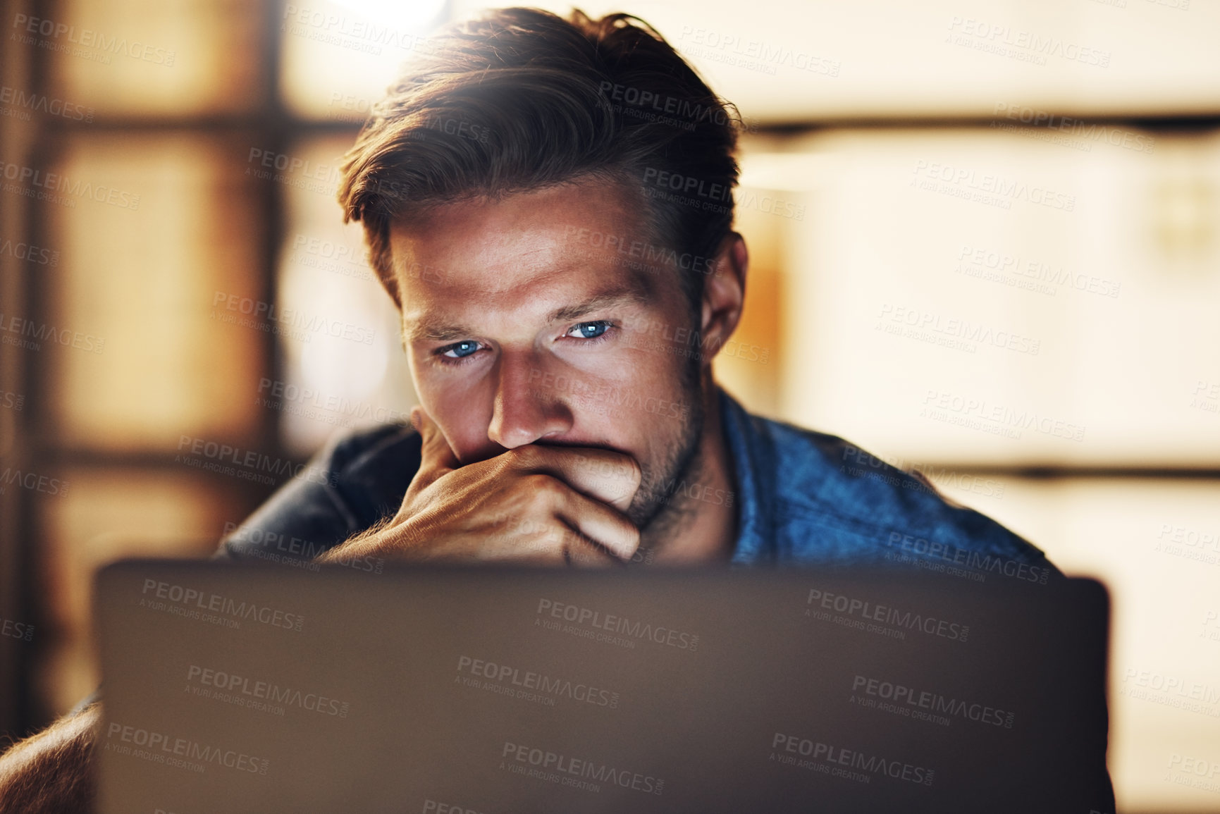 Buy stock photo Cropped shot of a handsome young male designer looking thoughtful while working late in his office