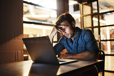 Buy stock photo Cropped shot of a handsome young male designer looking stressed while working late in his office