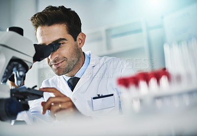 Buy stock photo Shot of a scientist using a microscope in a lab