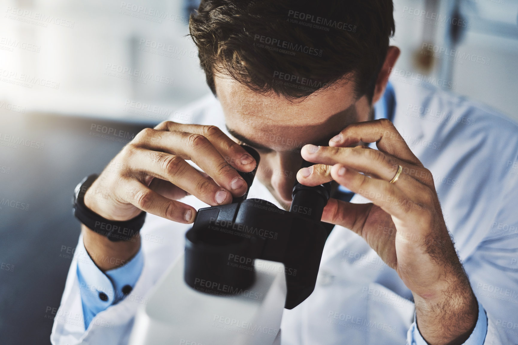 Buy stock photo Shot of a scientist using a microscope in a lab