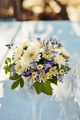 Buy stock photo High angle shot of a vase filled with flowers on a table at a tea party outside