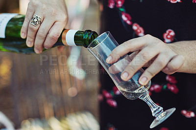 Buy stock photo Closeup shot of an unrecognizable woman pouring champagne into a glass at a tea party outside