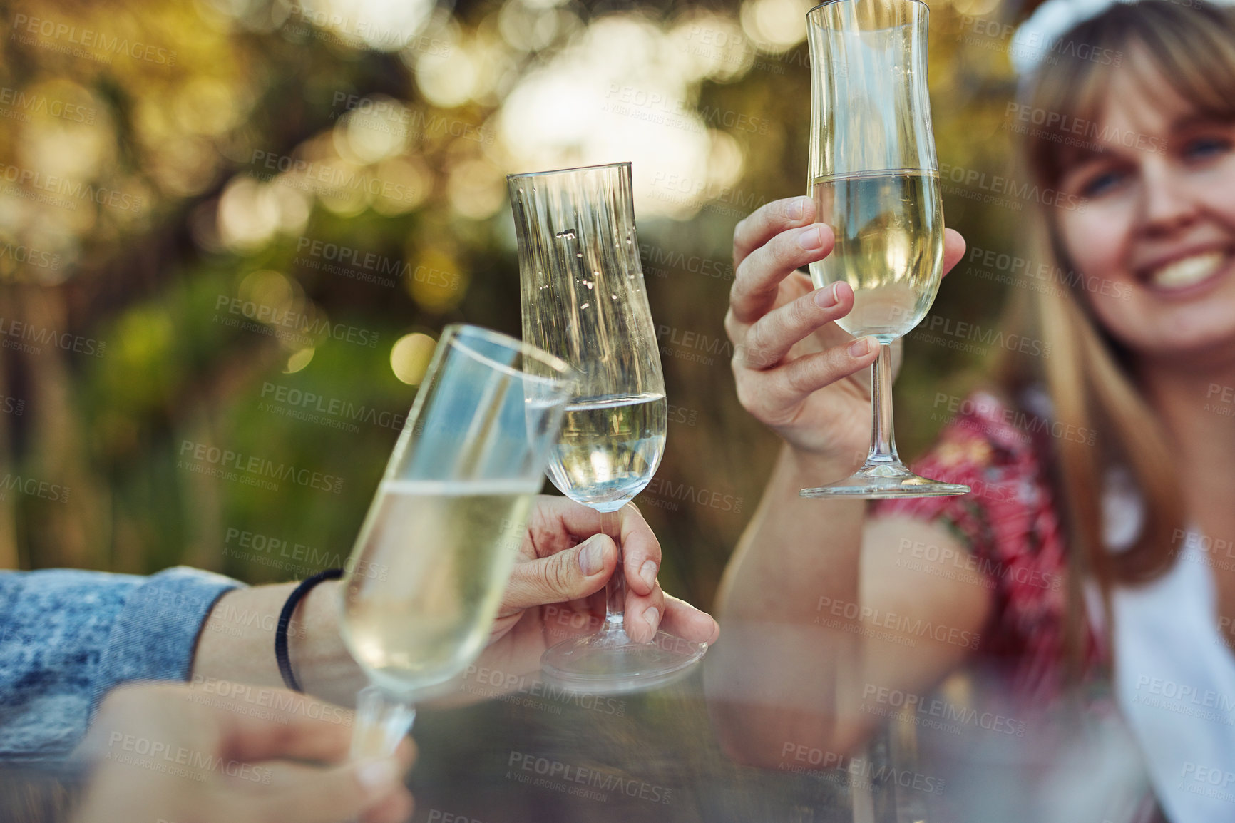 Buy stock photo Cropped shot of unrecognizable women toasting with champagne at a tea party outside