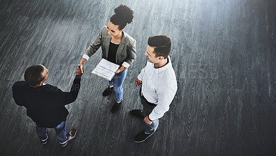 Buy stock photo High angle shot of two businesspeople shaking hands in an office