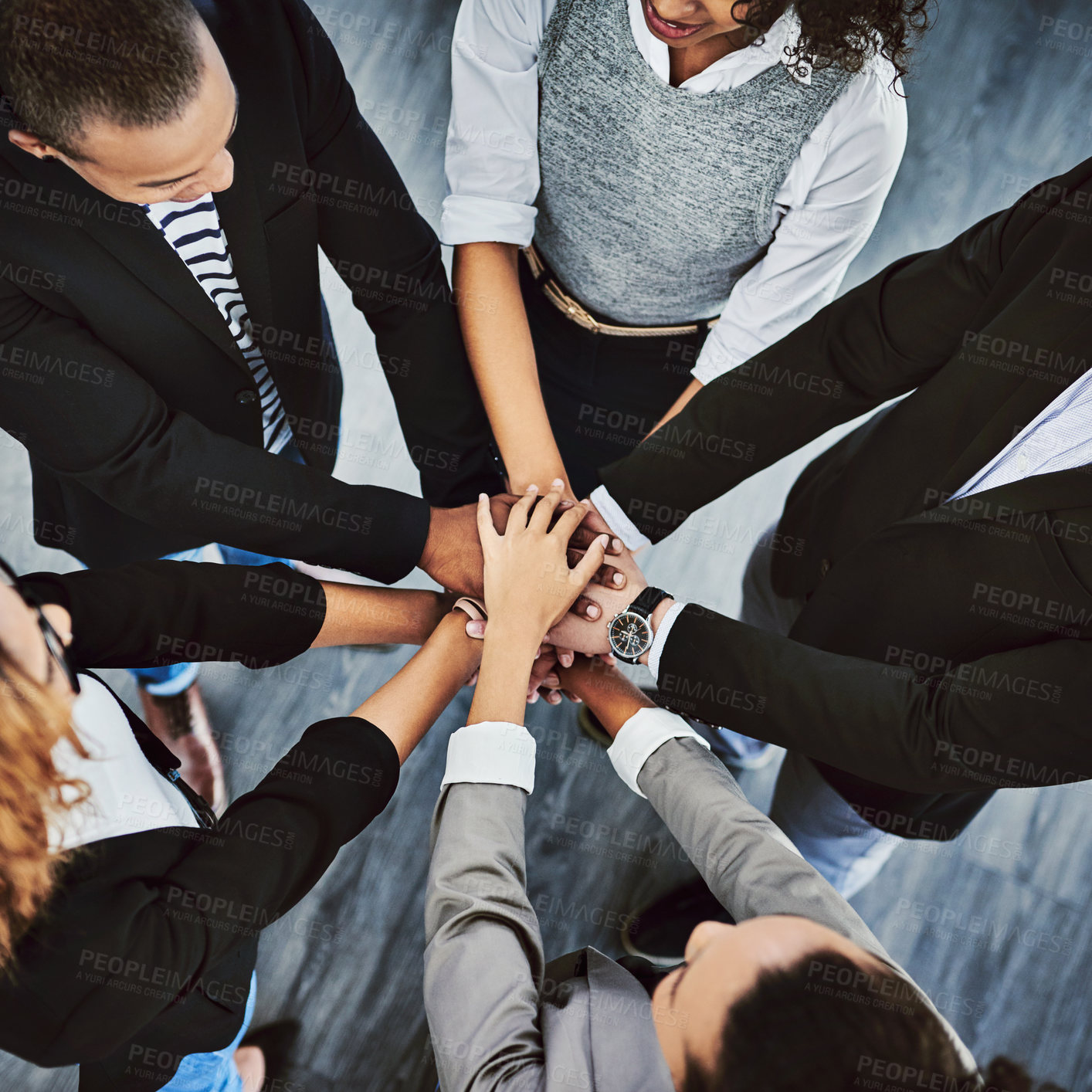 Buy stock photo High angle shot of a group of businesspeople joining their hands together in a huddle