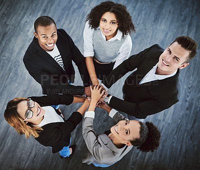Buy stock photo High angle shot of a group of businesspeople joining their hands together in a huddle