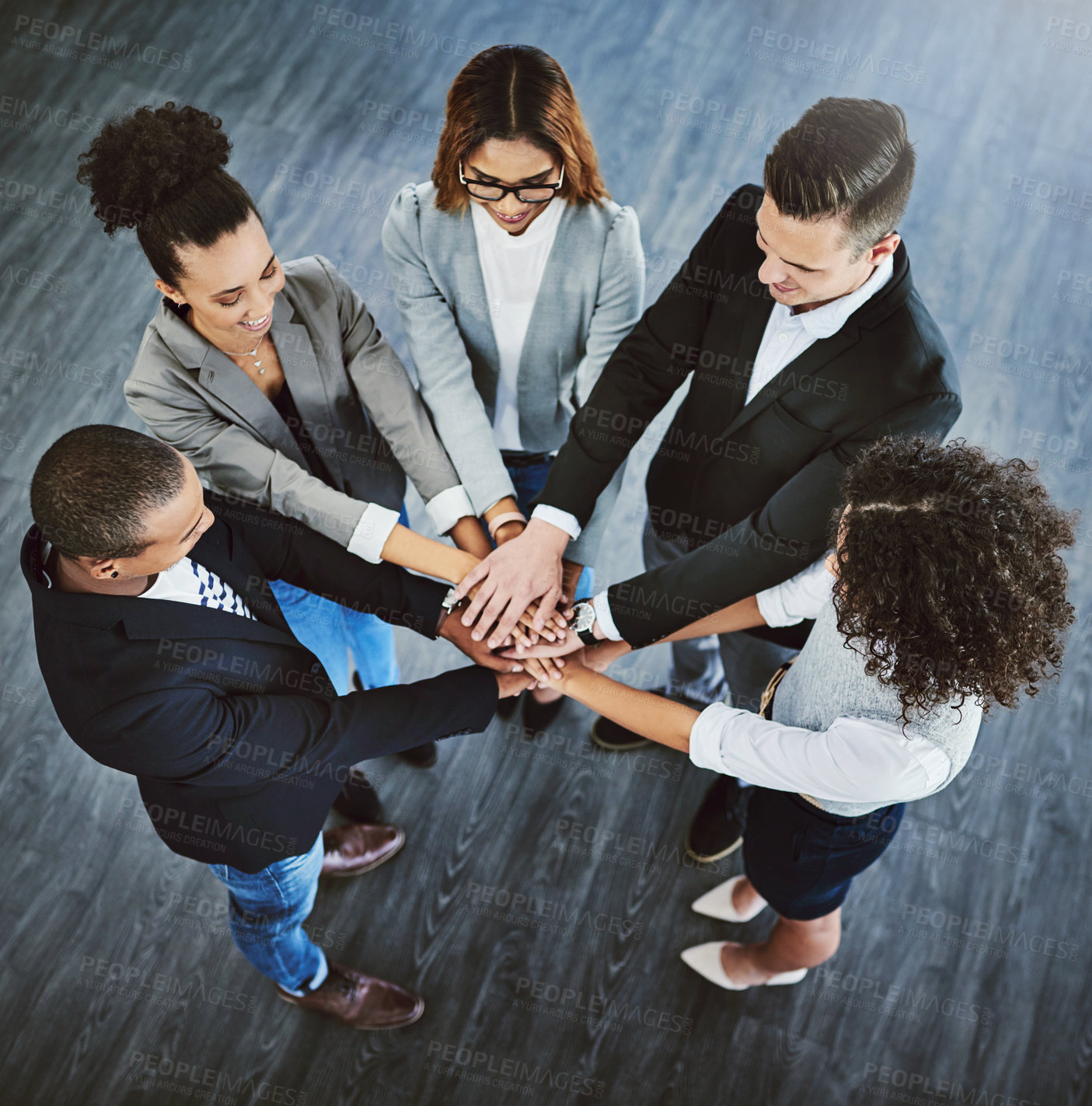 Buy stock photo High angle shot of a group of businesspeople joining their hands together in a huddle