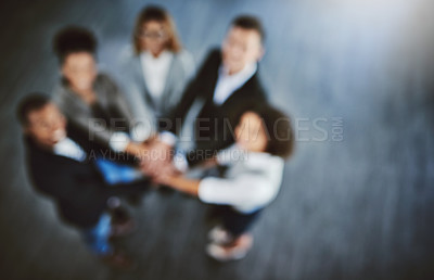 Buy stock photo Defocused shot of a group of businesspeople joining their hands together in a huddle