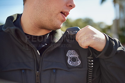 Buy stock photo Cropped shot of an unrecognizable policeman radioing in with headquarters