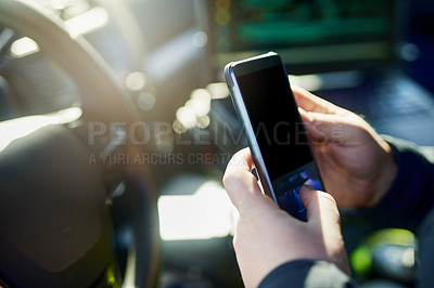 Buy stock photo Cropped shot of an unrecognizable male police officer using his cellphone while out on patrol