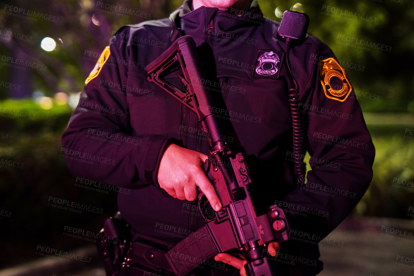 Buy stock photo Cropped shot of an unrecognizable policeman standing with his assault rifle while out on patrol