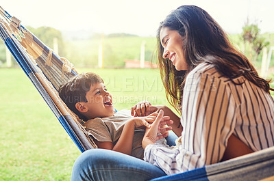 Buy stock photo Cropped shot of an attractive young woman and her son bonding outside on the hammock