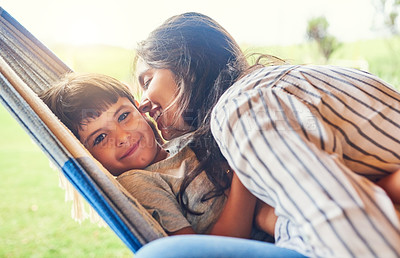 Buy stock photo Cropped shot of an attractive young woman and her son bonding outside on the hammock