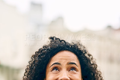Buy stock photo Cropped shot an unrecognizable woman looking up while out in the city