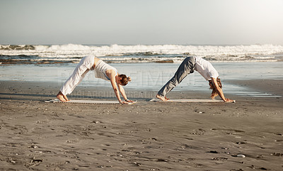 Buy stock photo Shot of a young couple practising yoga together on the beach