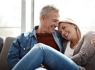 Buy stock photo Shot of an affectionate mature couple relaxing together on the sofa at home