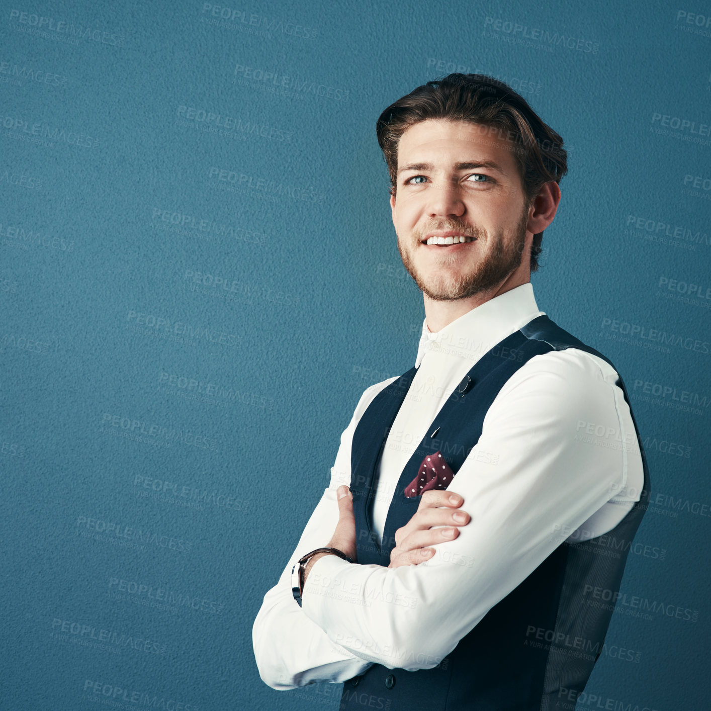 Buy stock photo Studio shot of a handsome young businessman standing with his arms crossed against a coloured background