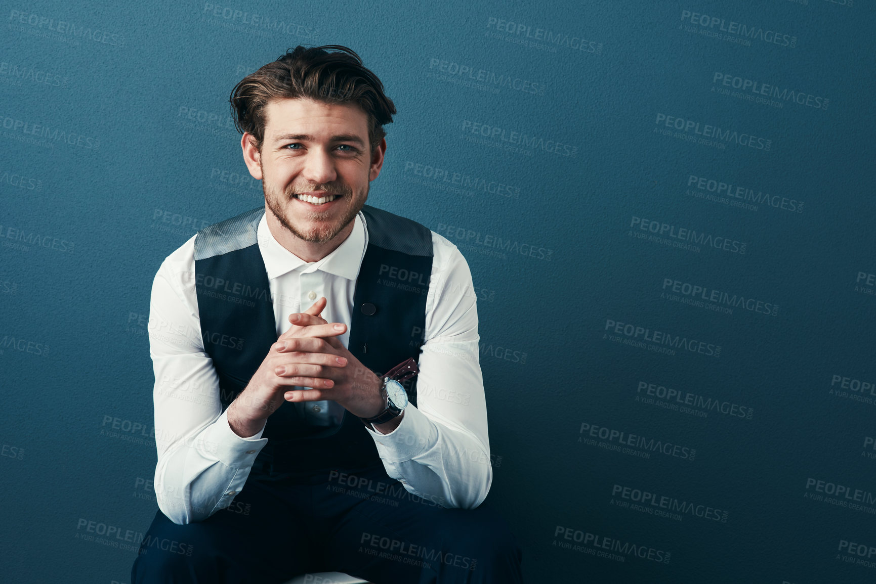 Buy stock photo Studio shot of a handsome young businessman posing against a blue background