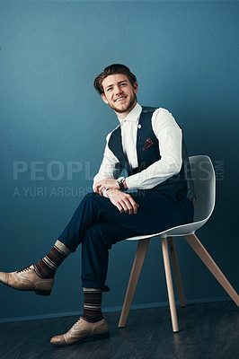 Buy stock photo Studio shot of a handsome young businessman posing against a blue background