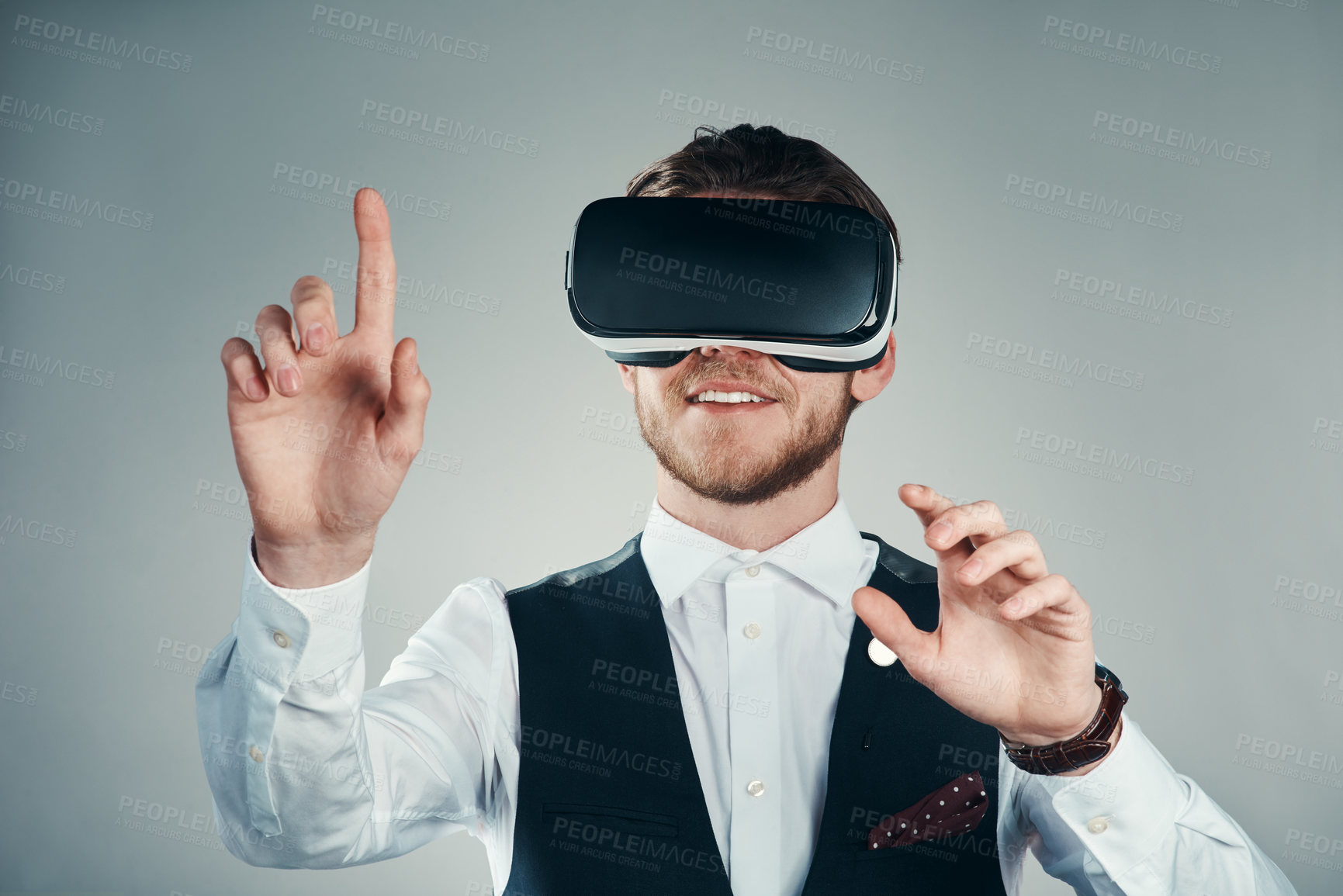 Buy stock photo Studio shot of a handsome young businessman using a vr headset against a grey background