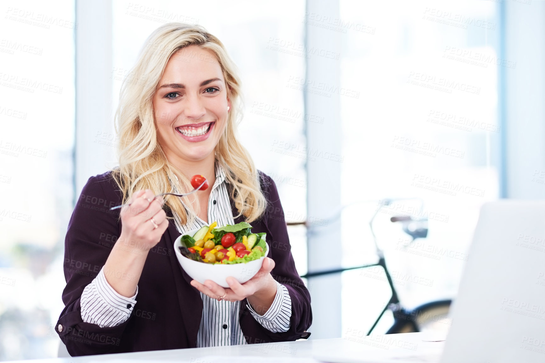 Buy stock photo Cropped portrait of an attractive young businesswoman eating a salad while working in her office