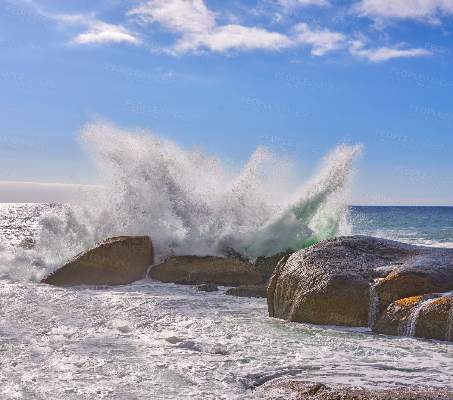 Buy stock photo Ocean waves crashing onto a rocky beach and shore under blue sky copy space in Camps Bay, Cape Town, South Africa. Scenic seascape view of tidal sea washing over rocks, boulders on tourism attraction