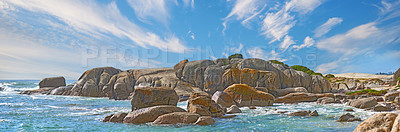 Buy stock photo Panorama sea view of Camps Bay, Cape Town, South Africa with boulders, rocks and blue sky with copy space. Oceans waves washing onto a rough, rocky beach shore. Travel and tourism overseas and abroad