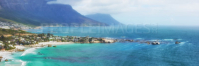 Buy stock photo A peaceful view of the Clifton ocean at the Atlantic seaboard with an island and mountains in the background. A city surrounded by blue fresh water and a foggy cloudy sky with copy space.