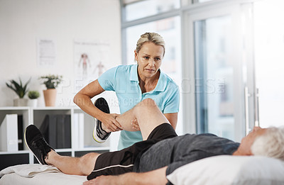 Buy stock photo Cropped shot of a mature female physiotherapist working with a senior male patient in her office