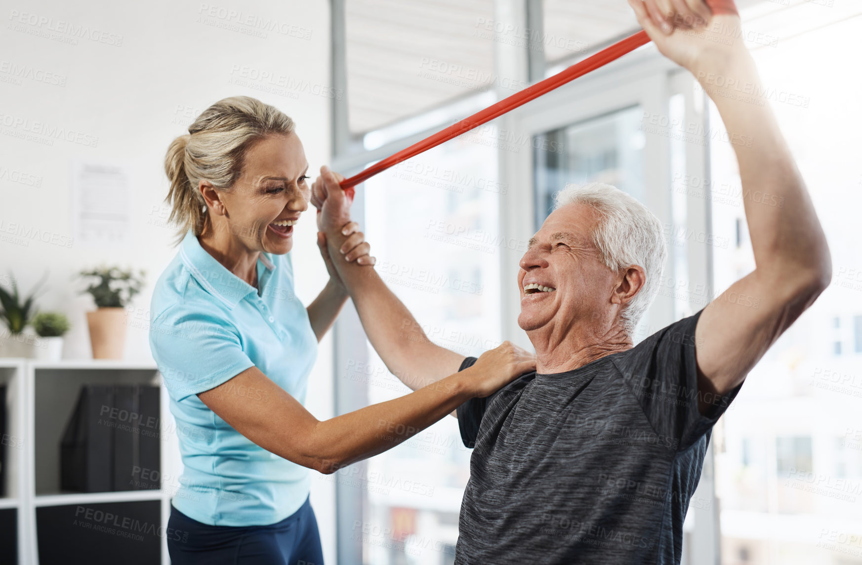 Buy stock photo Physical therapy, stretching band and senior patient with medical support, help and happy for healthcare services. People, doctor or chiropractor consulting with elderly client for shoulder strength