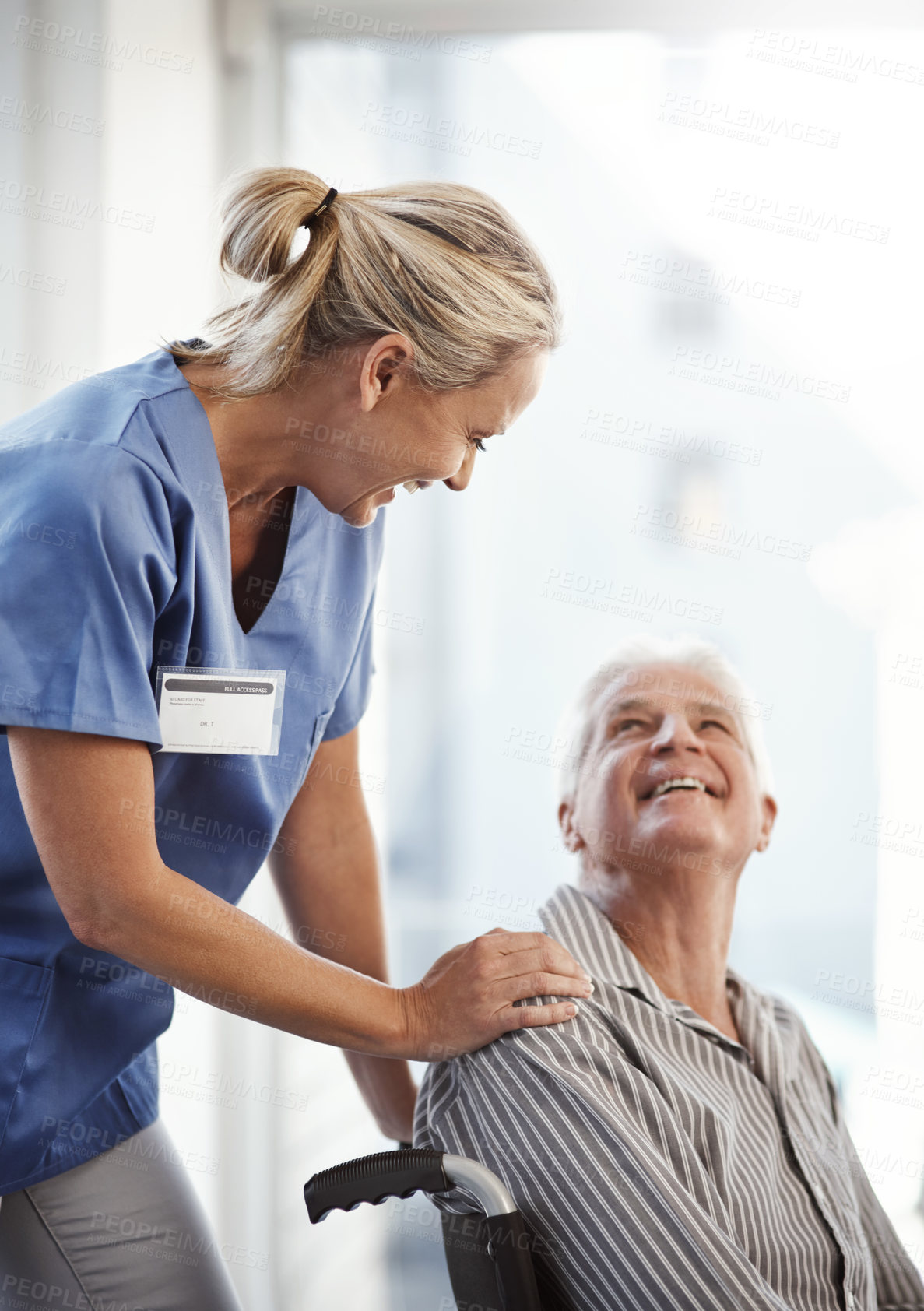 Buy stock photo Cropped shot of a mature female nurse and her senior male wheelchair-bound patient in the hospital