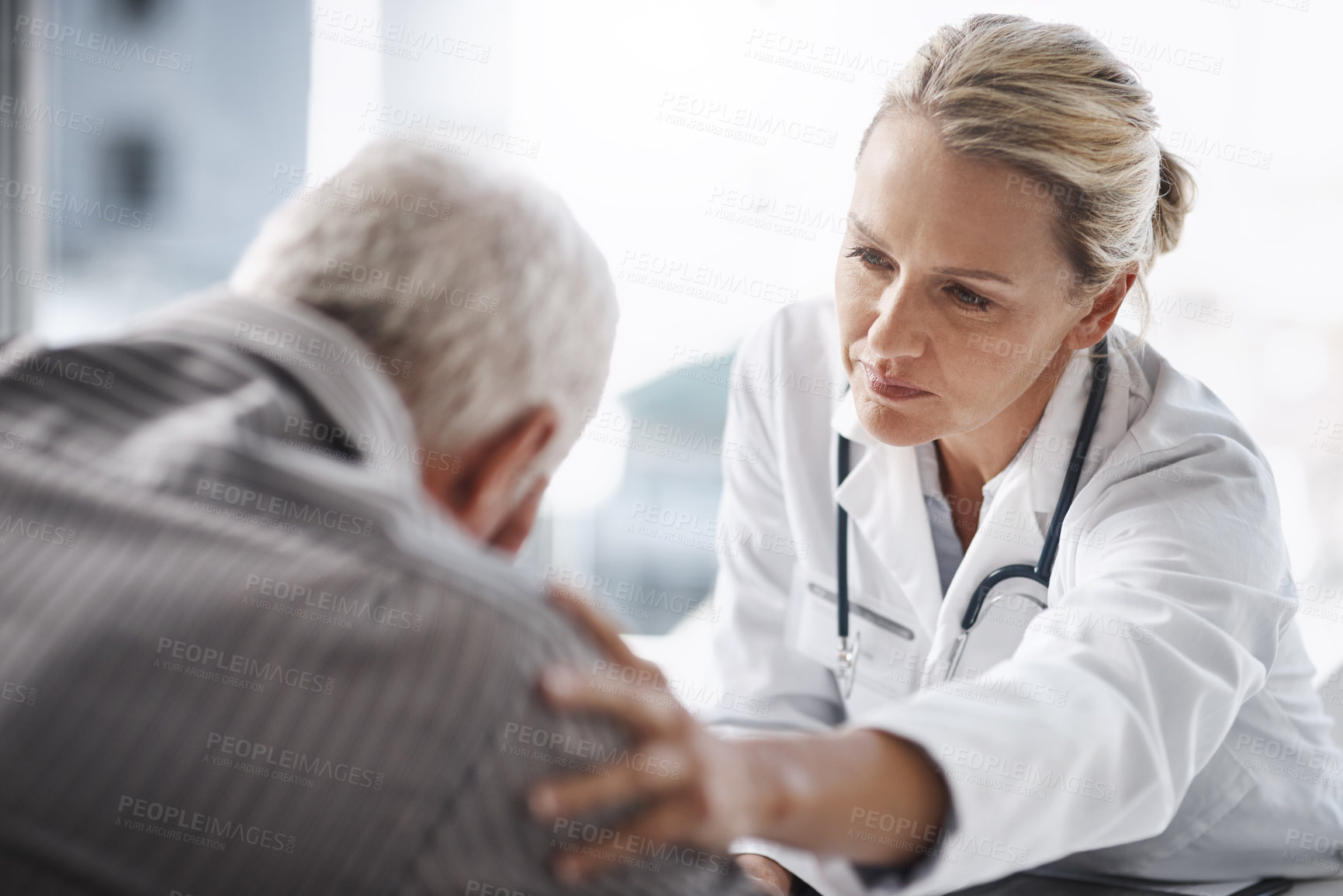 Buy stock photo Cropped shot of a mature female doctor working with a senior male patient in her office in the hospital