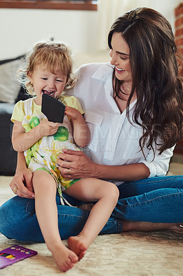 Buy stock photo Cropped shot of a beautiful young mother spending time with her adorable little daughter in the living room at home