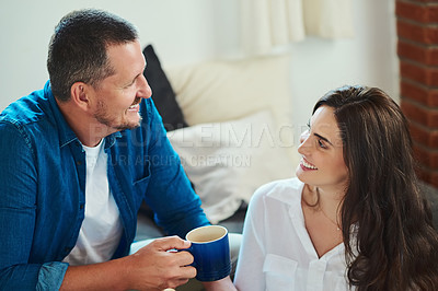 Buy stock photo Happy, couple and coffee in home with love, comfort and relax on lazy weekend. Man, woman and tea on living room sofa for sharing memories, healthy relationship and commitment development in marriage