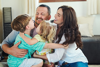 Buy stock photo Shot of an adorable young family spending time together in the living room at home