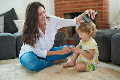 Buy stock photo Shot of a young beautiful mother brushing her adorable little daughter's hair in the living room at home