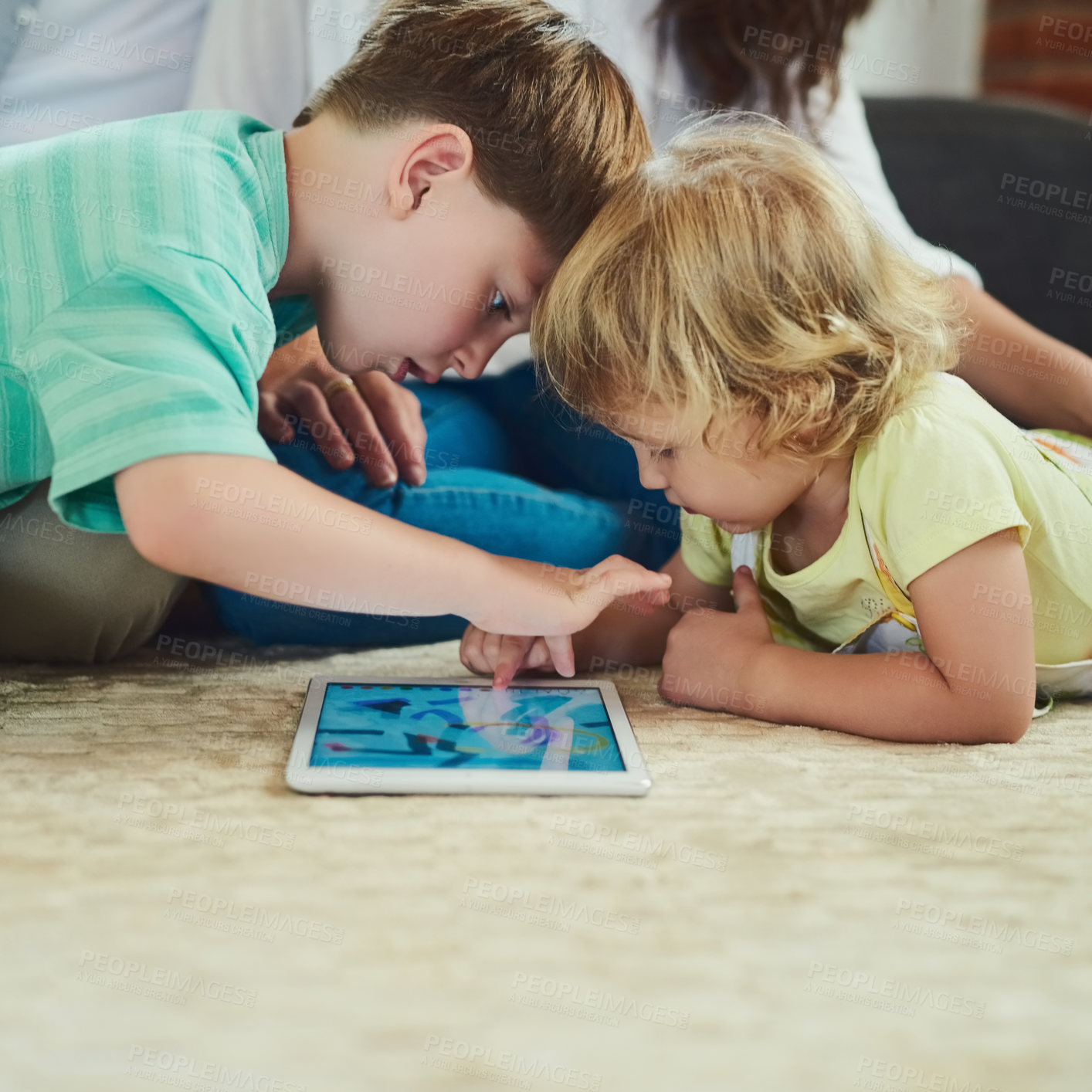 Buy stock photo Cropped shot of an adorable brother and sister using a tablet together on the floor in the living room at home