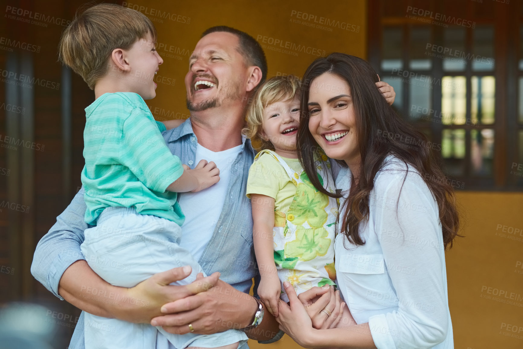 Buy stock photo Cropped shot of a young happy family spending time together in the backyard at home