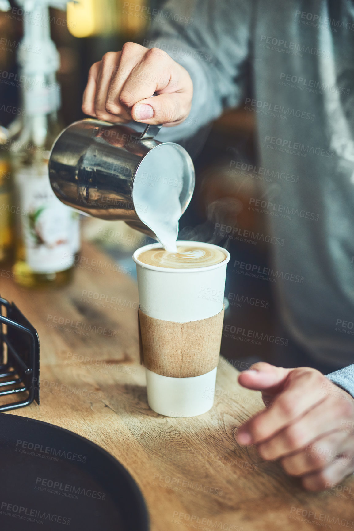 Buy stock photo Closeup shot of an unrecognizable barista pouring milk into a cup of freshly brewed coffee in a cafe