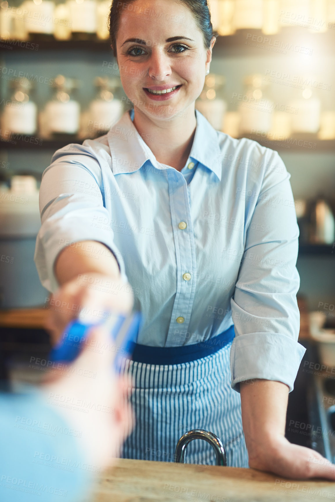 Buy stock photo Portrait of a young woman receiving a credit card payment from a customer in a cafe