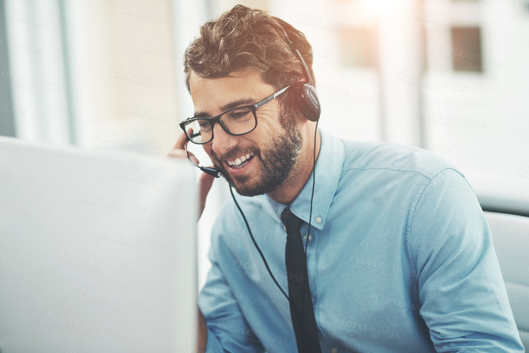 Buy stock photo Shot of a happy young man working in a call center