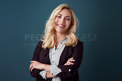 Buy stock photo Studio shot of a beautiful young businesswoman posing against a blue background