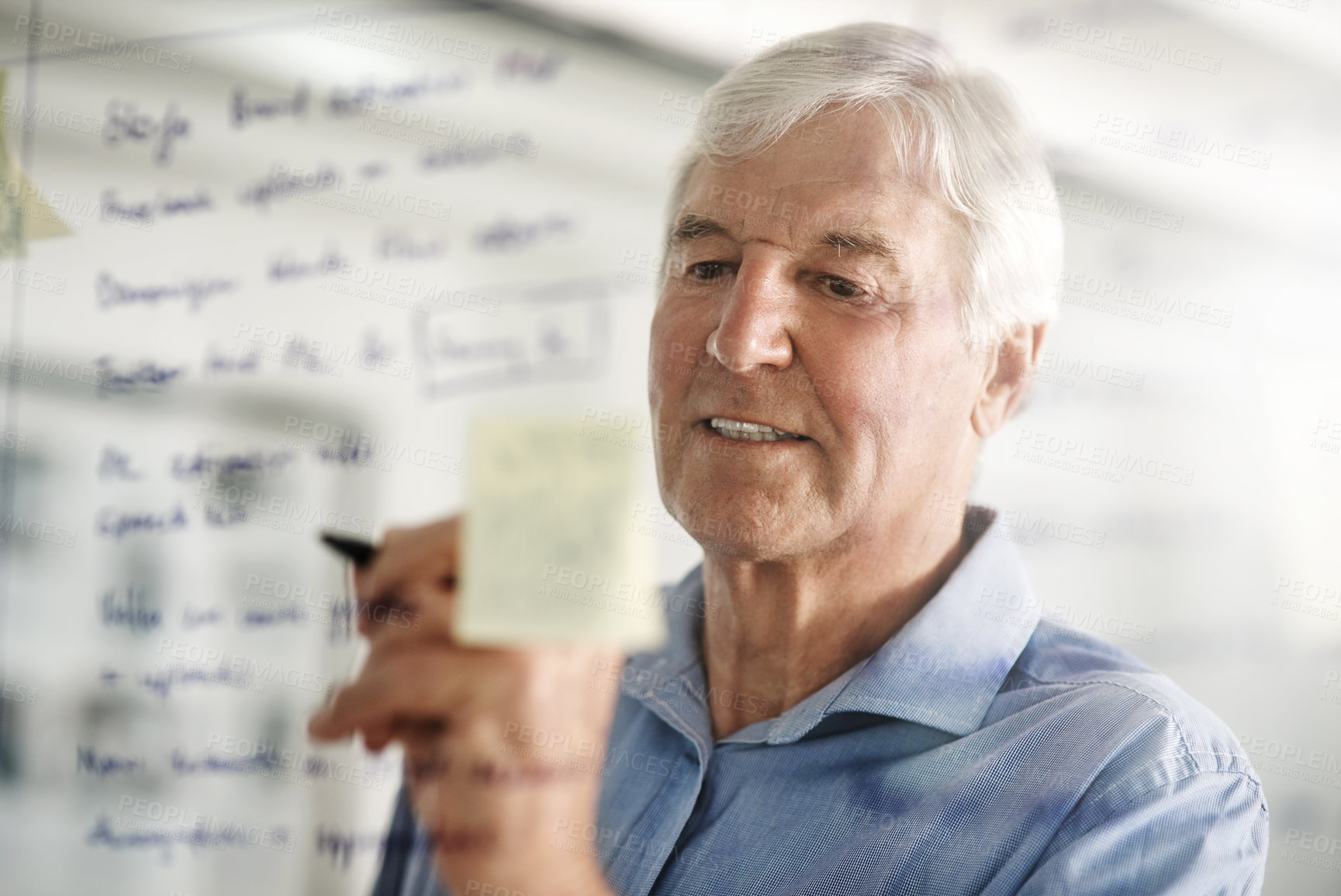 Buy stock photo Cropped shot of a senior businessman writing down ideas with a pen marker on a glass wall in the office