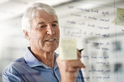 Buy stock photo Cropped shot of a senior businessman writing down ideas with a pen marker on a glass wall in the office