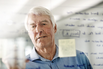 Buy stock photo Cropped shot of a senior businessman writing down ideas with a pen marker on a glass wall in the office
